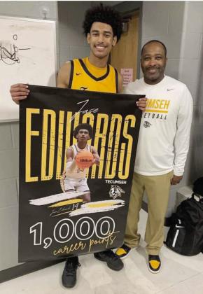 Tecumseh senior Jase Edwards, with his father and coach Bryant Edwards, pose with his banner after the shooting guard reached 1,000 career points last month. Photo provided.