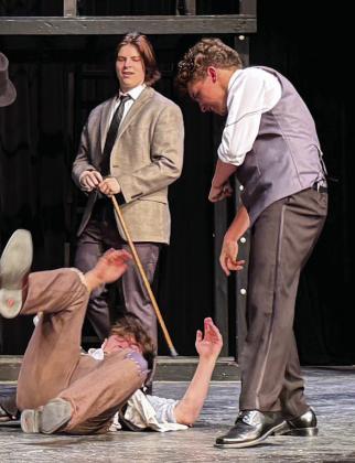 Crutchie (Aaron Aguirre) gets beaten and taken away by Snyder (Tyler Johnson) and Morris (Earl Crabb).