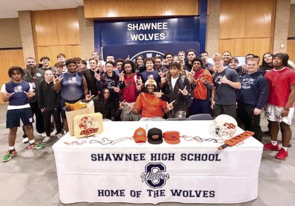 The Shawnee Wolves football team surrounds Ja’Qwon Evans, pistols firing, in celebration of his signing with OSU. Photos Provided