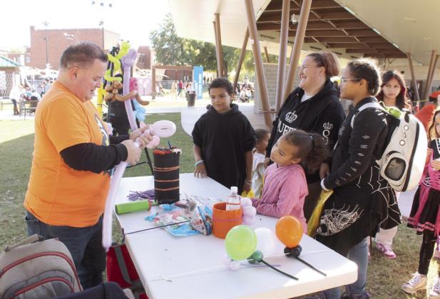 Matt Woodland, of OKC Balloon Twisting by Matt, creates a sword for a girl.