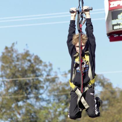 Ryker Flores of Shawnee braves the Extreme Inflatables Zipline, following his brother.