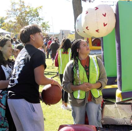Savannah Talton, a volunteer with the Shawnee Fall Youth Volunteer Program, watches as a young man shoots hoops. Talton volunteered at the basketball attraction for about four hours that day.