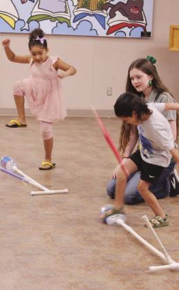 State 4-H STEM Innovator Tori Nelms watches as Lena Marks, 5, of Meeker, and Colton Hayes, 5, of Shawnee, launch the rockets they built during 'Build It: Ready, Set, Blast Off!'