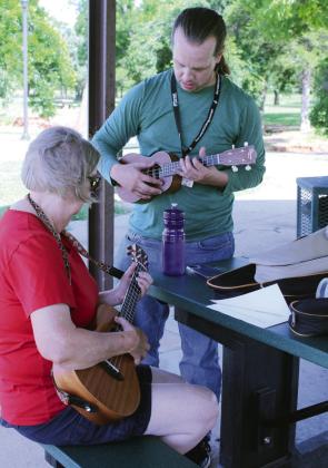 Aaron Pence helps Edie Talley with her ukulele chords.