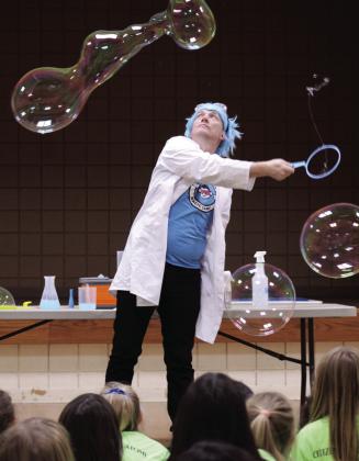Professor Bucket, aka Joe Coover, with Funky Monkey Magic demonstrates how to make large bubbles, with the help of guar gum and spraying mist in the air, during the 'Bubble Party' at Tecumseh Public Library on July 31. Natasha Dunagan, Countywide &amp;amp; Sun