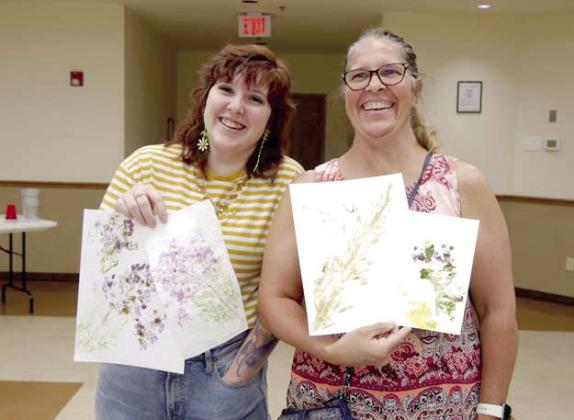 Library customers show off the flower art they created at the Tecumseh Public Library. Photo provided.