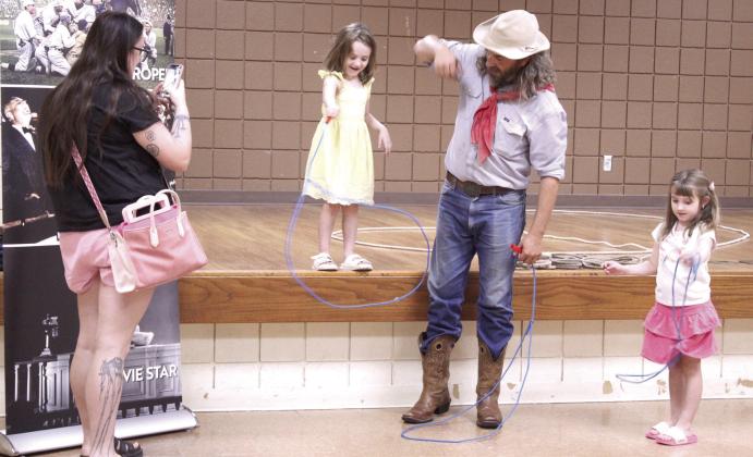 Buckaroo Bart, aka Bart Taylor with the Will Rogers Museum and Oklahoma Historical Society, teaches Maxxine Fox, 4, and Lydia Fox, 5, both of Shawnee, their first rope trick during the