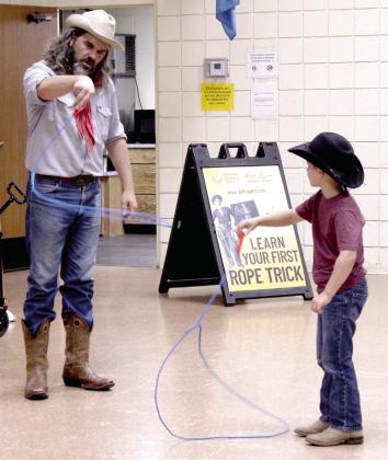 Buckaroo Bart teaches Judah Hassen, 6, of Maud, his first rope trick during the 'Readin' and Ropin' program at Tecumseh Public Library on Aug. 3.