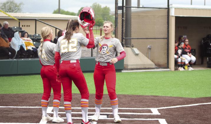 Dale sophomore Heartly Snyder, far right, hits helmets with her teammates after hitting a homerun in the third inning of the game with Wayne.