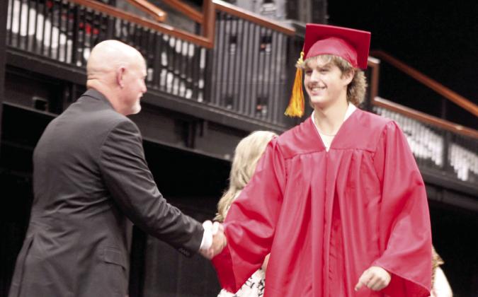 Maddox Caldwell shakes hands with Dale Board of Education Clerk Ronnie Newton during the Dale High School graduation at FireLake Arena on May 22. DHS graduated 46 seniors this year. Natasha Dunagan, Countywide &amp;amp; Sun