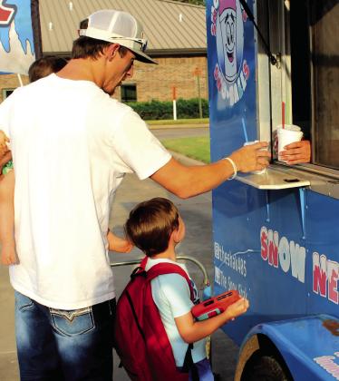 A family gets their free snow cones from The Snow Shak during the Sixth Annual Shawnee BancFirst Back to School Bash on Aug. 6. In addition to free snow cones, BancFirst gave away free hot dogs and backpacks full of school supplies. Shannon Chandler, BancFirst Regional Sales and Marketing Coordinator, said they had between 100 to 150 people attend the Shawnee event and around 100 in total at the Tecumseh and Mc-Loud events this year. Natasha Dunagan, Countywide &amp;amp; Sun