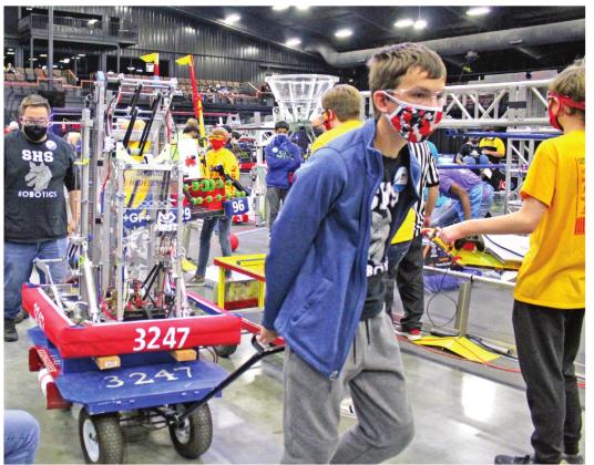 The Shawnee High School Robopack robot (#3247) is pulled away after a quarterfinal round during the Oklahoma Regional FIRST Robotics Competition at FireLake Arena on March 12. Coach Cullen Birney walks behind the robot. The team was a finalist in the championships, but lost in the last two rounds.