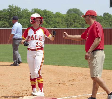 Dale sophomore Brooke Sheline gets a fist bump from Coach Bryce Clemons after landing on first base.