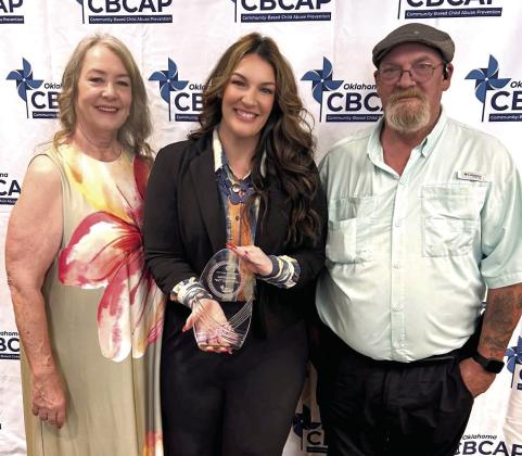 KC Campbell (center), recipient of the Mary Ellen Wilson Award, celebrates with her parents, Suzie and Thad Campbell, following the 2026 Outstanding Child Abuse Prevention Awards ceremony in Oklahoma City. Photo provided