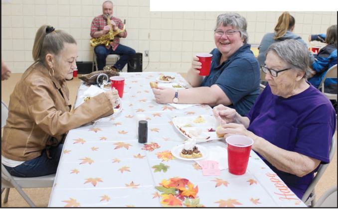 Barbara Glover, Jean Cutting and Claudia Rice enjoy their meal and the saxophone music of Terry Woodward of Shawnee during the 18th Annual Tecumseh Family Thanksgiving Dinner on Nov. 23 at the Tecumseh City Hall Auditorium. Woodward is the OKC Police Department Chaplain, and he called to volunteer his musical services for the event this year. Countywide &amp; Sun/Natasha Dunagan