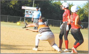 Macomb junior Deja Givens (#3) crosses first as Maud junior Lenna Harris makes the catch in the game at Maud on Aug. 8. Also shown is Macomb sophomore Addy Beauchamp.