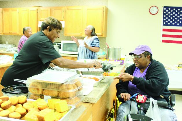 Earnie Carthen serves sweet potatoes to Niecy McDade during the Anniversary Celebration. Also shown are Margie Sumlin and Beverly Cooks. Natasha Dunagan, Countywide &amp; Sun