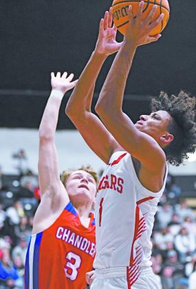 Memphis Burdine puts a shot in the lane for North Rock Creek Saturday in the finals of the Okemah Tournament. Defending for Chandler is Zaedyn Harkins (3). North RockCreek won 79-48.