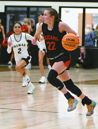 Pictured right, Kadence Munn surveys the court as she brings the ball up on a fast break for North Rock Creek Saturday. The Lady Cougars lost to Okemah in the finals, 57-40.