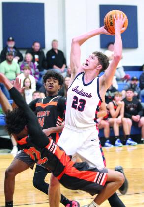 After stealing the ball, Asher’s Mikey VanSchuyver aims for the basket, as two Carney defenders fall, at the end of the first quarter of the Nov. 22 home game. The Indians won in overtime, 71-66.