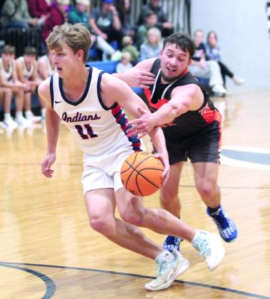 A Carney player tries to steal the ball as Asher’s Andrew Overstreet takes it to the paint during the second quarter of the Nov. 22 home game.