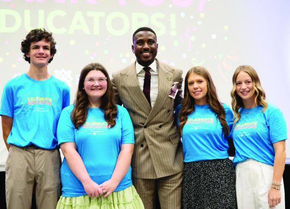 Keynote speaker Michael Bonner poses with area students who shared Master of the Ceremonies duties. Photo by Jesse Monday Media