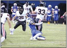 Bethel senior Reagan Curry hangs on to Meeker senior Ajay Lynch and keeps him from