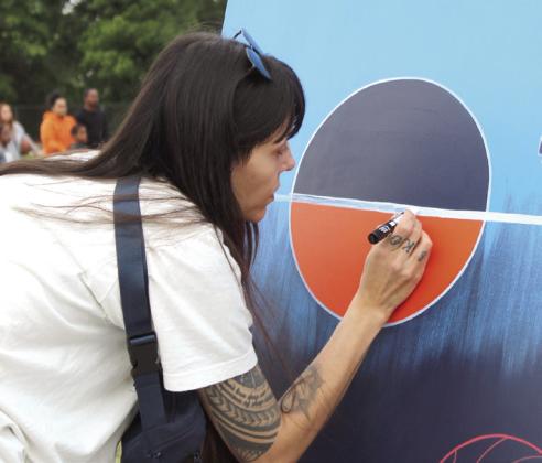 Savannah Tallbear is an OKC-based indigenous painter of the Kaw Nation who is part of the Thunder Artist Group (TAG), a skilled group of Oklahoma artists that are commissioned to create various forms of artwork for Thunder events during the 2025-26 season. Tallbear's father, Amos, works for St. Anthony's Shawnee. Photo by Natasha Dunagan, Countywide &amp; Sun. Cutline by Julie Talton, Countywide and Sun.