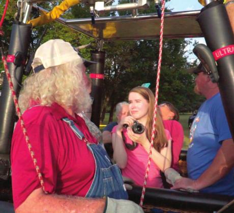 Countywide &amp; Sun journalist Kendra Johnson stands in a tethered hot-air balloon, while talking with the balloon’s pilot and taking pictures, during the FireLake FireFlight Balloon Festival last year. Photo provided by Ronald Johnson.
