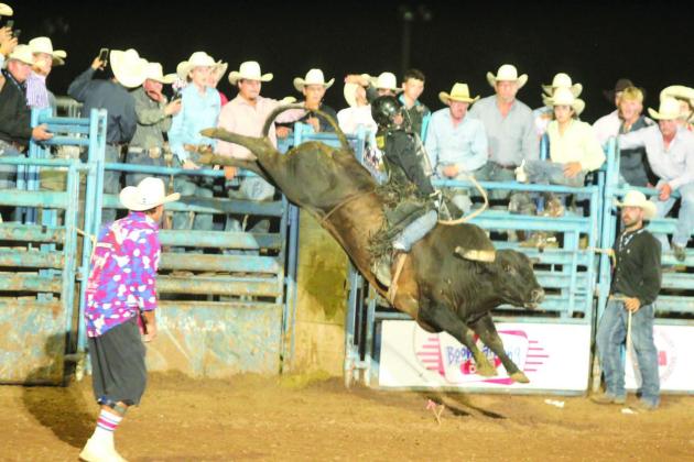 As the lights flash in Arena #3, Ty Lavergne of Suphur, LA, competes in bull riding during the championship round on the evening of July 17. Lavergne placed sixth in the overall event standings.