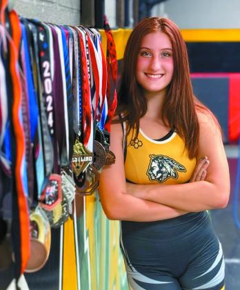 Kylei Gokey poses for a professional photo in her Tecumseh High School singlet and with the 35 medals she's won so far. Gokey has been wrestling since seventh grade and will go into her sophomore year, having been a state-qualifier as a freshman and having competed at national tournaments in Fargo, ND, and Westfield, IN, over the summer. Photo provided