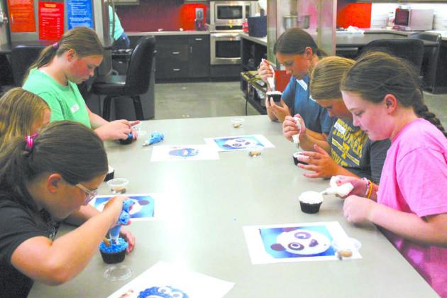 During the 4-H Skills Day held at North Rock Creek High School on June 20, members learned how to decorate cupcakes from Susan Crow. Other classes were making reverse tie-dyed shirts, musical shakers, first aid kits, &amp; a flower craft, as well as learning about animal biosecurity and podcasting. They also worked on fair projects and a service project for a veteran. Shown, clockwise, are Nila Marsh, Reagan Nickell, J.J. Harless, Randee Jasper, Hailee Townsend &amp; Taycie Baker.