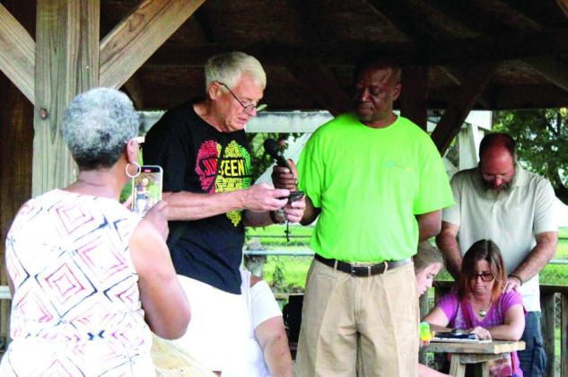 Shawnee Mayor Ed Bolt, center, reads a proclamation for Juneteenth, as Epicurean Delight (Epic Sno Cones) owner David Henry holds the microphone and Gloria Wallace, of the Dunbar Heights Association, shoots a video during the Juneteenth Celebration behind the sno cone stand on June 19.
