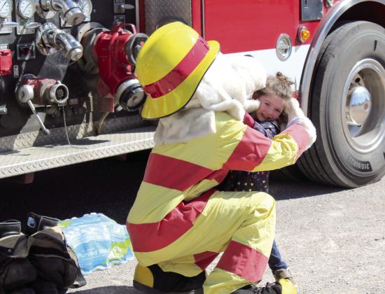 Sparky the Fire Dog gets a hug from Alyssa Whitecotton, 3, of Earlsboro, during the Touch-A-Truck and Beyond event at the CPN Festival Grounds on April 1. Sparky came with the McLoud Fire Department. Countywide &amp; Sun/Natasha Dunagan