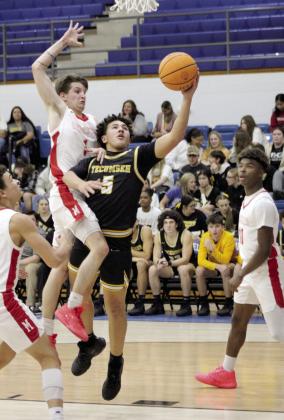 After stealing the ball, Tecumseh’s Aveon Stokes aims for the basket and is fouled by McLoud’s Bryce Cowns in the Consolation Round of the First United Basketball Classic, held on Dec. 9 at Bethel High School. McLoud won, 60-39, for the third-place trophy.