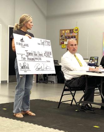 Casi Cox-Bays, Athletic Director for Tecumseh Public Schools, presents a 'check' in the amount of $5,000 from the FireLake Gives Back program to Superintendent Robert Kinsey.. Julie Talton, Countywide &amp;amp; Sun
