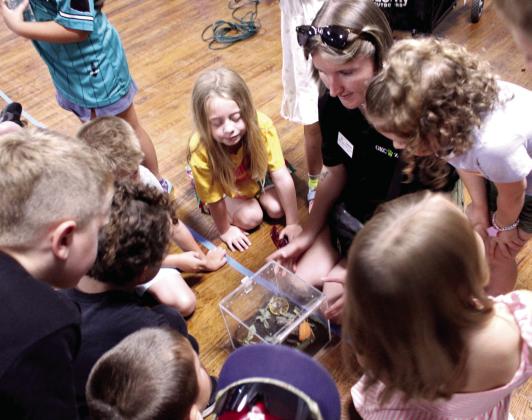 Children look into an acrylic box where an African millipede lives, as OKC Zoo Outreach Supervisor Laynie Rodzon tells them more about the detritivore during the "Pollinator Pals: Fluttering Fun with the OKC Zoo" McLoud Public Library program, held at the American Legion on June 11. Today (June 18), "Tunes and Tales with Erin Yeaman" will be presented by the McLoud library at the American Legion at 11 am. Photos by Natasha Dunagan, Countywide & Sun