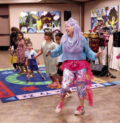 Candy Sparkles leads a line of children in the "Iggy Shuffle" conga line, as Captain Coconut plays the drums, during "The Dino-Drum Adventure" with The Smartipops, held at Shawnee Public Library on June 12. Attendees learned about Puerto Rican culture, including salsa dancing and the coqui frog. They also learned to play native percussion instruments. Today (June 18), "STEAM Kids - Big Blue Blocks" will be held at 3:30 pm.