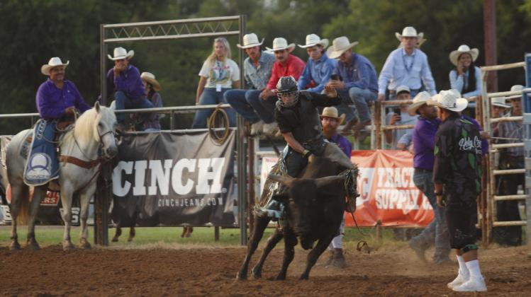Colton Johnson of Shawnee competes in the first go-round of bull riding at the IFYR on the evening of July 8. Johnson said he took a bull riding class two years ago and has "been riding ever since." Natasha Dunagan, Countywide &amp; Sun