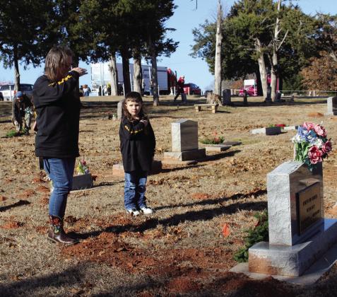 Penny Edwards and Kolton Edwards, 6, both of OKC, salute the grave of Army veteran Russell Glover at Romulus Cemetery after placing a wreath on it, Dec. 16, for National Wreaths Across America Day.