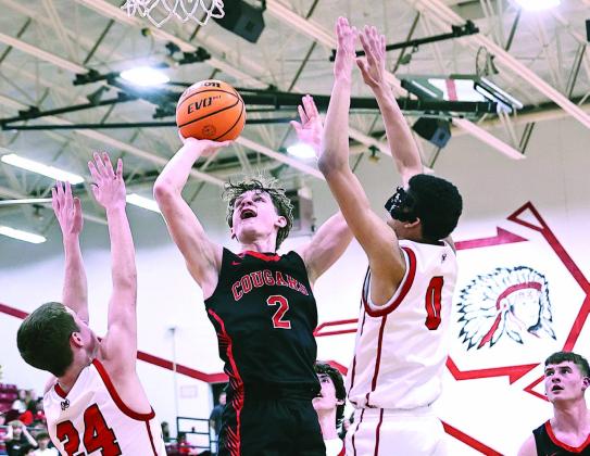 North Rock Creek's Kohen Warden goes up between two McLoud defenders to score. NRC won the matchup, 65-60, after trailing in the third. Photo Provided by Gowin Photography