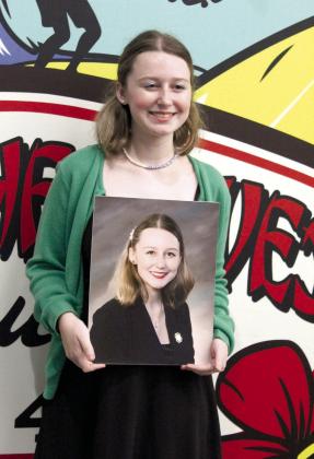 The 4-H Club Hall of Fame winner for 2022, Emma Collins poses with her portrait which hung at the Pottawatomie County Courthouse last year. Countywide &amp; Sun/Natasha Dunagan