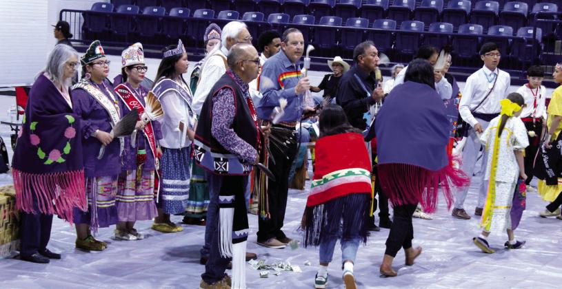 As part of the Gourd Dance, participants give money to individual dancers and join them in the dance, said SHS Indian Education Director Graham Primeaux in an email, during the Shawnee and Tecumseh Indian Education Powwow, held at the SHS Performing Arts and Athletic Center on June 13. Recipients can keep the money or donate it to the drum singers, who were the Warchief Singers in this case, said Primeaux.  See full caption below.