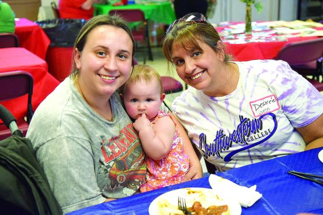Three generations of Johnson residents: Lily, Hazel and Desiree’ Herron, enjoy dinner provided at the Johnson Fall Festival.