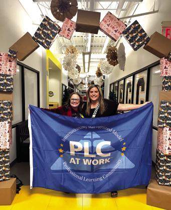 Tammy Giaudrone, Principal at Tecumseh Early Childhood Center, and Ashley Steward, Intervention Specialist proudly display the flag they were awarded last month to represent their achievement as a Professional Learning Community award recipient. Julie Talton, Countywide &amp; Sun