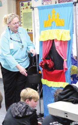Bethel Middle School Teacher Reda Marcussen helps with a bucket as two of her sixth-grade drama students practice their puppet show on April 11. Marcussen recently won the POE Excellence in Education Junior High Educator Merit Award and was named the Teacher of the Year. Countywide &amp;amp; Sun/Natasha Dunagan