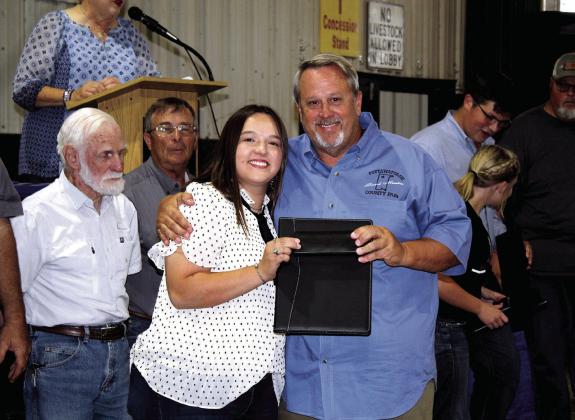 Fair Board Vice Chairman Matt Griffith presents a folder to his daughter Morley Griffith for serving on the first Pottawatomie County Free Fair Junior Fair Board on Sept. 10. The Junior Fair Board was the Griffiths’ idea to get teenagers involved in the Fair Board. Countywide &amp;amp; Sun/ Natasha Dunagan