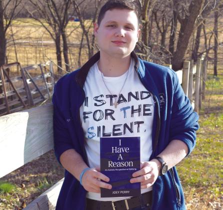 Author Joey Perry poses with his new memoir, “I Have a Reason: An Autistic Perspective on Bullying.” Perry will have a book launch and signing Dec. 2, 6-7 pm, at The Farmers Daughter Market. Kirk Smalley, of Stand for the Silent, will be at the event, as well. Photo provided.
