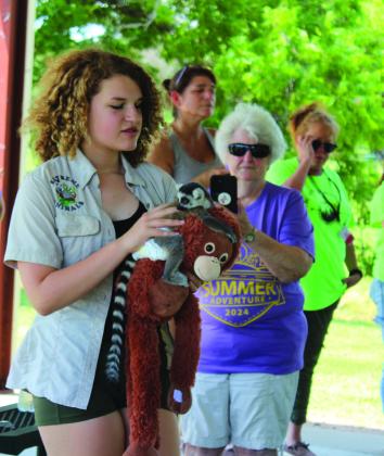 During the Tecumseh Pioneer Library Summer Reading Challenge Extreme Animals program at Slick Humphrey Park on June 13, Handler Keeley Knowles holds "King Julian" the Ring-Tailed Lemur, who is a four- to five-month-old female. Knowles said, contrary to the "Madagascar" movie, lemurs are led by females, so "King Julian should be Queen Julia." There are about 60 lemur species in Madagascar, said Knowles, whose grandmother owns the "zoo-to-you" in Tuttle.