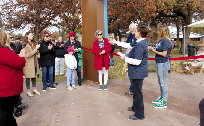 Shawnee Community Beautification Committee member Sherry Lankford thanks all those involved in the renovation of Woodland Veterans Park, including Dr. Kathy Laster, in black coat, CEO of the Avedis Foundation, for their donation. Lankford spoke just before the ribbon cutting for the park on Nov. 11. Countywide &amp; Sun/Natasha Dunagan